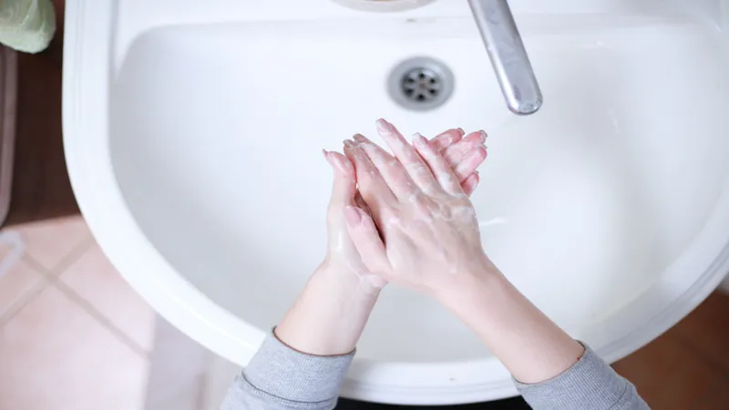 Händer som tvättas över ett handfat.
