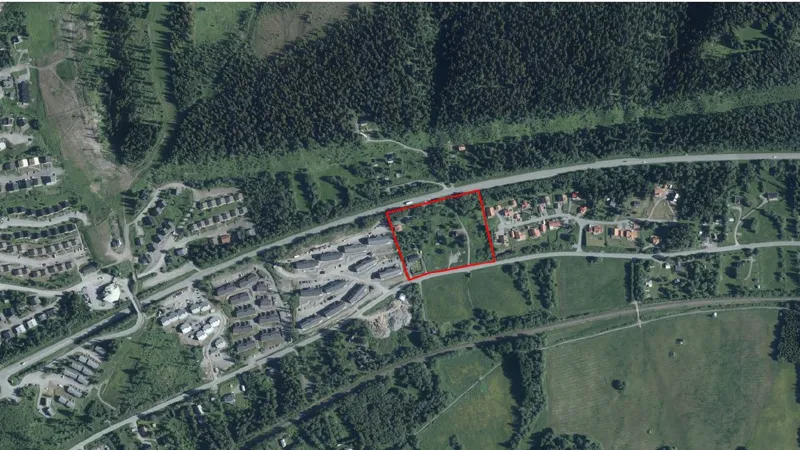 En flygbild av ett bostadsområde med ett rött markerat område i mitten.