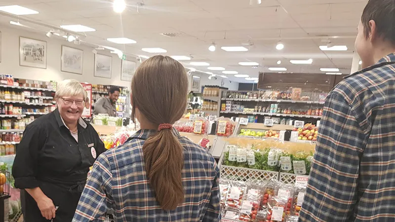 En grupp människor som står i en livsmedelsbutik.