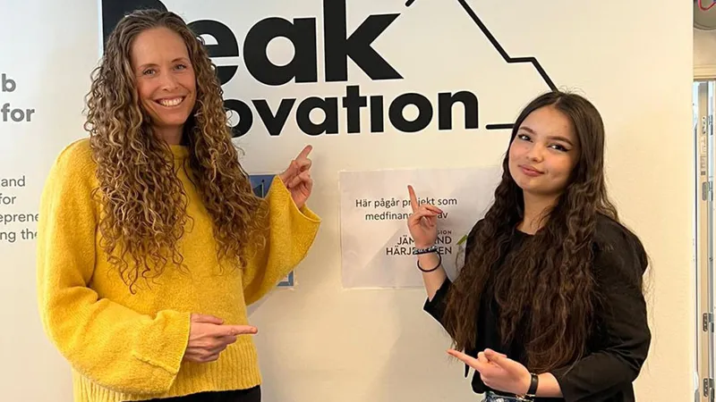 Två kvinnor står framför en skylt om innovation.