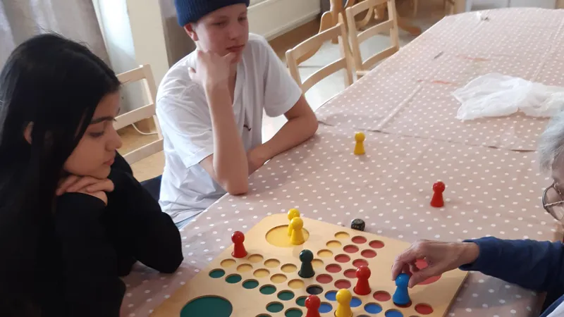 En grupp människor som sitter runt ett bord och spelar ett spel.