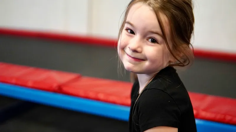 En liten flicka i en gymnastikhall.